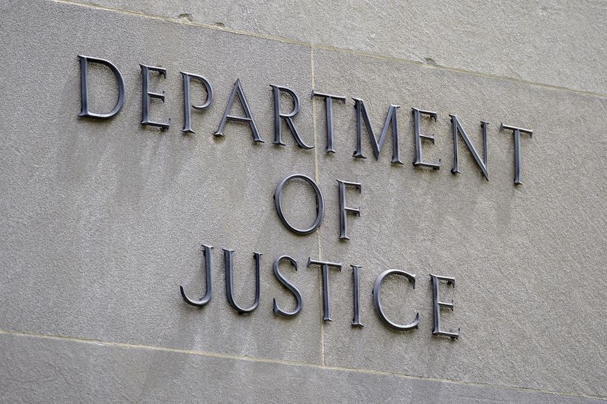 This May 4, 2021 file photo shows a sign outside the Robert F. Kennedy Department of Justice building in Washington. The Justice Department announced charges Wednesday against a man at a mental health facility in Florida who prosecutors say made illegal threats against President Biden. (AP Photo/Patrick Semansky)