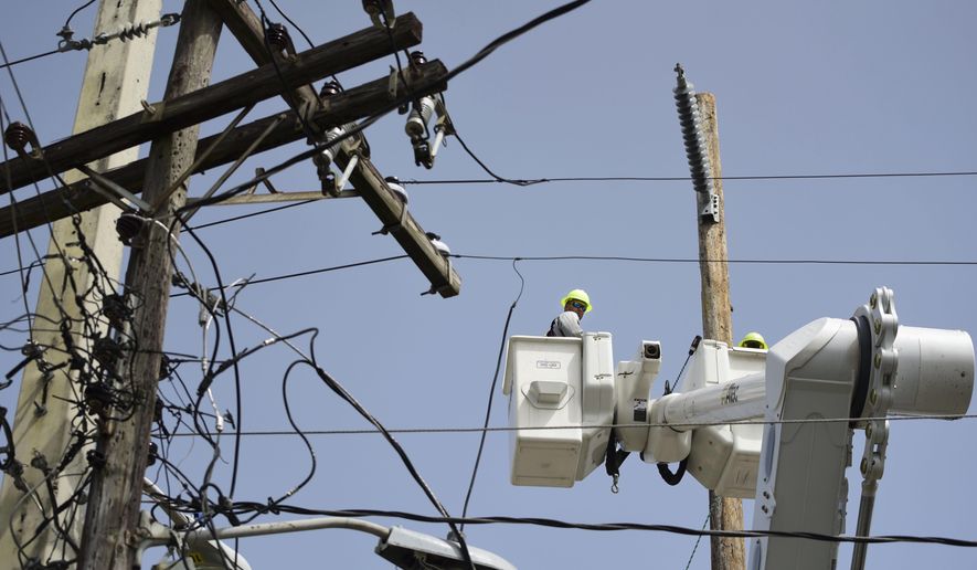 FILE - A brigade from the Electric Power Authority repairs distribution lines damaged by Hurricane Maria in the Cantera community of San Juan, Puerto Rico, Oct. 19, 2017. A federal judge overseeing a drawn-out debt-restructuring process for the power company ordered all parties to mediation on Wednesday, July 10, in the latest attempt to break an impasse that has sparked widespread anger and frustration. (AP Photo/Carlos Giusti, File)