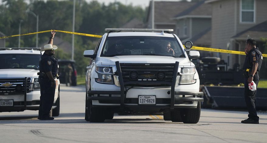 Harris County Sheriff's and Houston Police close off the neighborhood around Italian Cypress Trail on Thursday, July 11, 2024, in Houston. Police said Sunday that one person was killed and 13 others were wounded after an "uninvited guest" crashed a family barbecue and began shooting at partygoers (not at the location pictured here), prompting the other attendees to fire back. (Elizabeth Conley/Houston Chronicle via AP)
