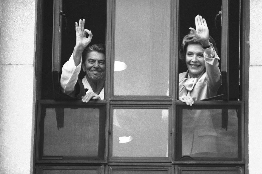 President Ronald Reagan gives the A-OK sign from the window of his hospital room at Bethesda Naval Medical Center in Maryland, July 18, 1985 as first lady Nancy Reagan waves to a small group below. The president is recovering from surgery performed Saturday to remove a cancerous polyp. (AP Photo/Scott Stewart)