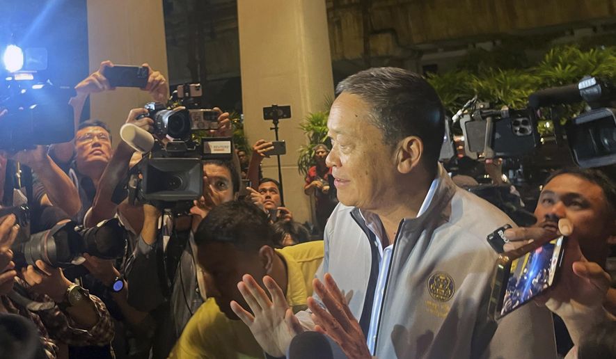 Thai Prime Minister Srettha Thavisin gestures as he is mobbed by the media upon arrival at Grand Hyatt Erawan in Bangkok, Thailand, Tuesday, July 16, 2024. Police said a number of people were found dead Tuesday in the luxury hotel in downtown Bangkok and poisoning is suspected. (AP Photo/Napat Kongsawad)