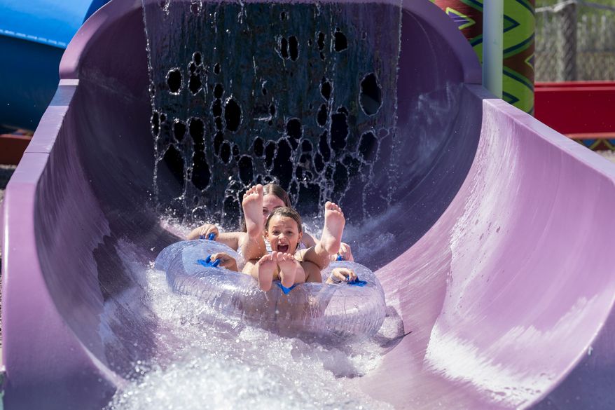 A brother and sister splash down a tube slide at Kalahari Resorts’ outdoor waterpark in celebration of National Waterpark Day. (Photo: Business Wire)