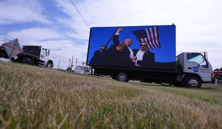 An electronic billboard displays images of former President Donald Trump from his recent rally at the Butler Farm Show, Thursday, July 18, 2024, in Butler, Pa. (AP Photo/Eric Gay)