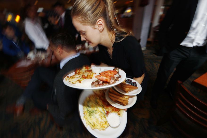 A waitress carries breakfast dishes to customers at a restaurant on Jan. 20, 2017, in east Denver. In a recent column, New York Times restaurant critic Pete Wells announced he's leaving the beat because the constant eating has led to obesity and other health problems. (AP Photo/David Zalubowski, File)
