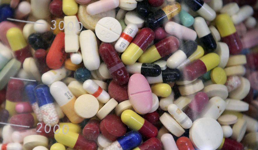 Prescription drugs are seen in a glass flask at a state laboratory in Taylorsville, Utah, on July 6, 2017. (AP Photo/Rick Bowmer, File)