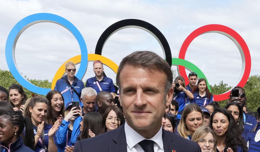 FILE - French President Emmanuel Macron leaves after posing with French athletes as he visits the Olympic Village ahead of the 2024 Summer Olympics, Monday, July 22, 2024, in Paris, France. (AP Photo/Michel Euler, Pool, File)