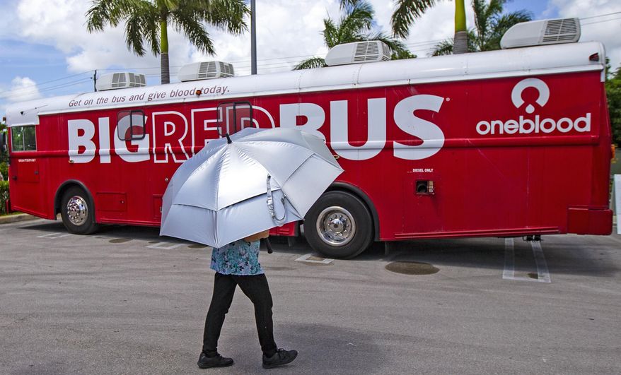 A health care worker walks by the Big Red Bus from OneBlood outside at Cano Health in Hialeah, Fla., July 29, 2020. Oneblood, which serves much of the southeast United States, is facing a ransomware attack, officials said Wednesday, July 31, 2024. (David Santiago/Miami Herald via AP)