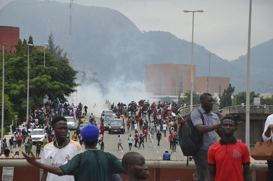 Police fired tear gas during a protest in Abuja, Nigeria, Thursday, Aug. 1, 2024. Thousands of mostly young people poured onto the streets across Nigeria on Thursday as they protested against the country's worst cost-of-living crisis in a generation. Security forces fired tear gas to disperse some of the protesters in the capital, Abuja. (AP Photo/Olamikan Gbemiga )