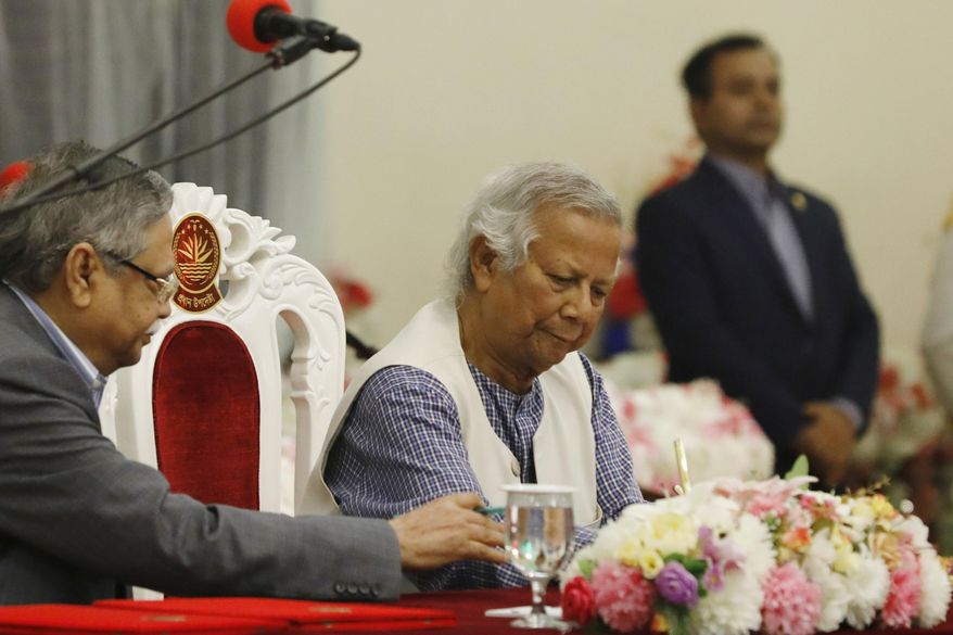 Nobel laureate Muhammad Yunus signs a document after taking the oath of office as the head of Bangladesh's interim government, in Dhaka, Bangladesh, Thursday, Aug. 8, 2024. (AP Photo/Rajib Dhar)