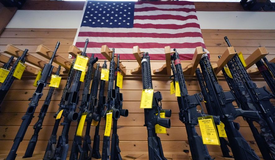 A variety of AR-15-style rifles are displayed under an American flag at the Kittery Trading Post, Friday, Aug. 9, 2024, in Kittery, Maine. (AP Photo/Charles Krupa) **FILE**