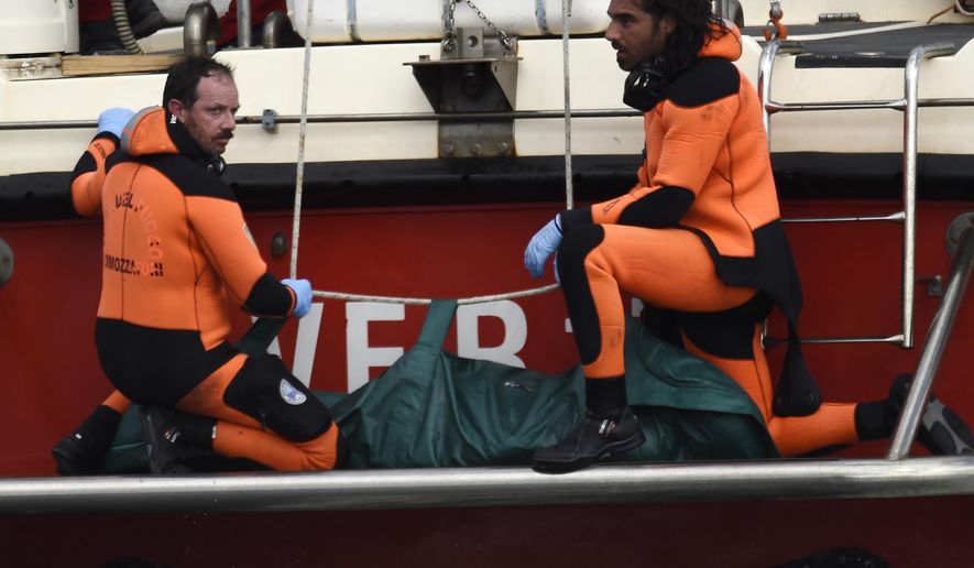Italian firefighter scuba divers bring ashore, in the green bag, the body of one of the victims from the British-flagged vessel Bayesian, Wednesday, Aug. 21, 2024. The yacht was hit by a violent sudden storm and sank early Monday, while at anchor off the Sicilian village of Porticello near Palermo, in southern Italy. (AP Photo/Salvatore Cavalli)
