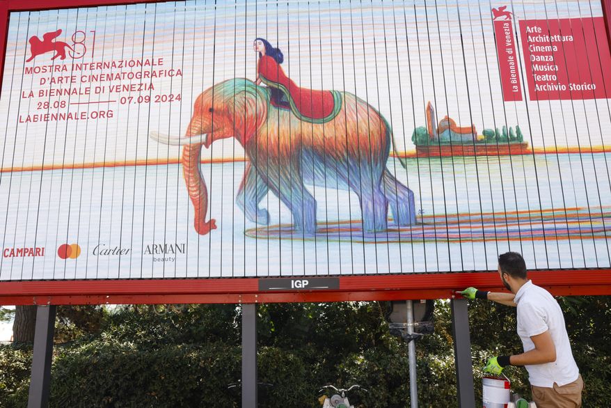 Workers paint signage for the 81st edition of the Venice Film Festival in Venice, Italy, on Tuesday, Aug. 27, 2024. The festival runs from Aug. 27 until Sept. 8. (Photo by Vianney Le Caer/Invision/AP)