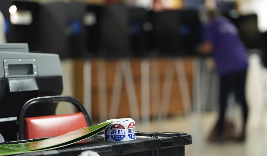 Stickers reading "I voted" rest beside a ballot scanner as a voter fills in a ballot at a privacy booth, during voting in Florida's primary election, Tuesday, Aug. 20, 2024, in a voting bureau at the American Legion in South Miami, Fla. (AP Photo/Rebecca Blackwell, File)