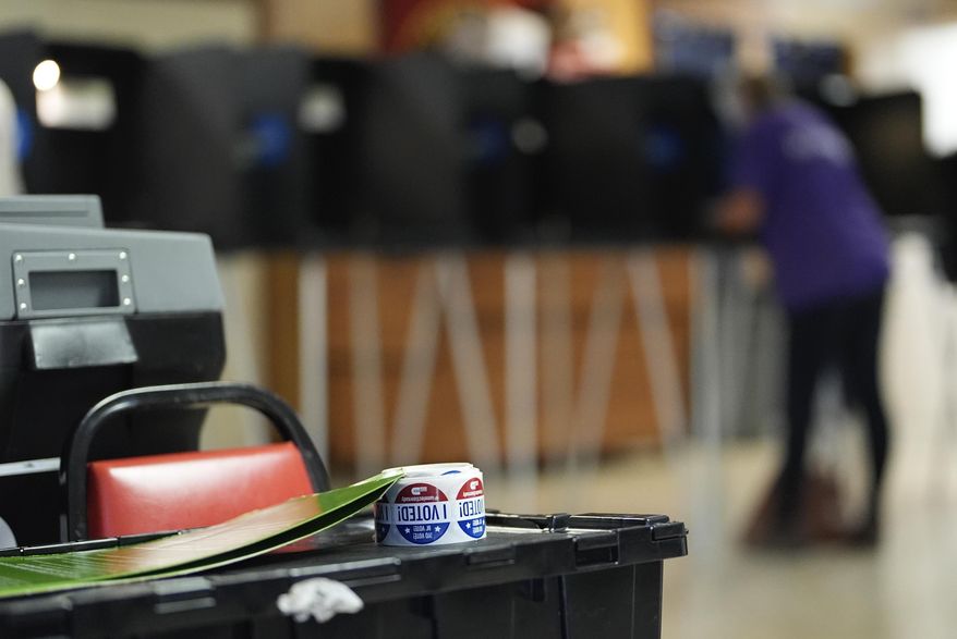 Stickers reading "I voted" rest beside a ballot scanner as a voter fills in a ballot at a privacy booth, during voting in Florida's primary election, Tuesday, Aug. 20, 2024, in a voting bureau at the American Legion in South Miami, Fla. (AP Photo/Rebecca Blackwell, File)
