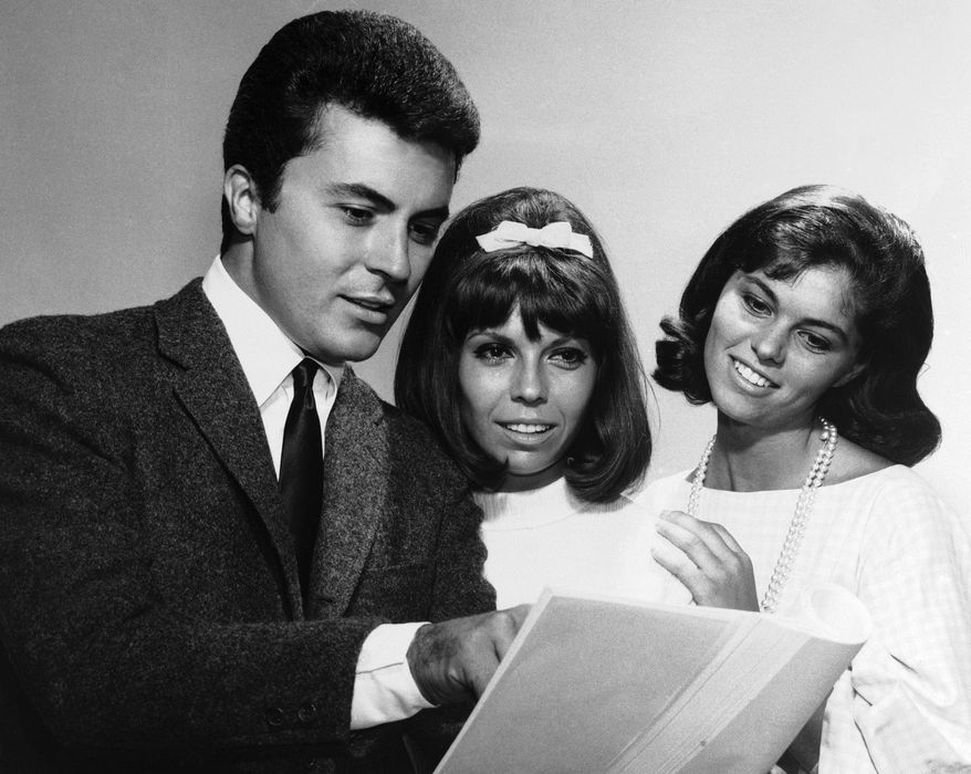 FILE - James Darren — left, one of the stars of the film For Those Who Think Young — chats with Nancy Sinatra, centre, and Claudia Martin about their film debuts, August 13, 1963. (AP Photo, File)