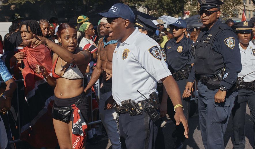 Police move revelers from the street after a shooting on Eastern Parkway, near the corner of Franklin Avenue, during the West Indian Day Parade on Monday, Sept. 2, 2024, in the Brooklyn borough of New York. (AP Photo/Andres Kudacki)