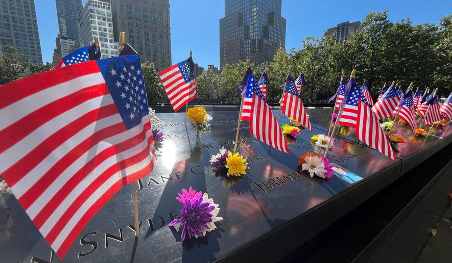 Flags and flowers are placed by the names of those killed during the Sept. 11, 2001, attacks at the reflecting pools at the National September 11 Memorial & Museum in New York on Tuesday, Sept. 10, 2024. (AP Photo/Donald King) **FILE**