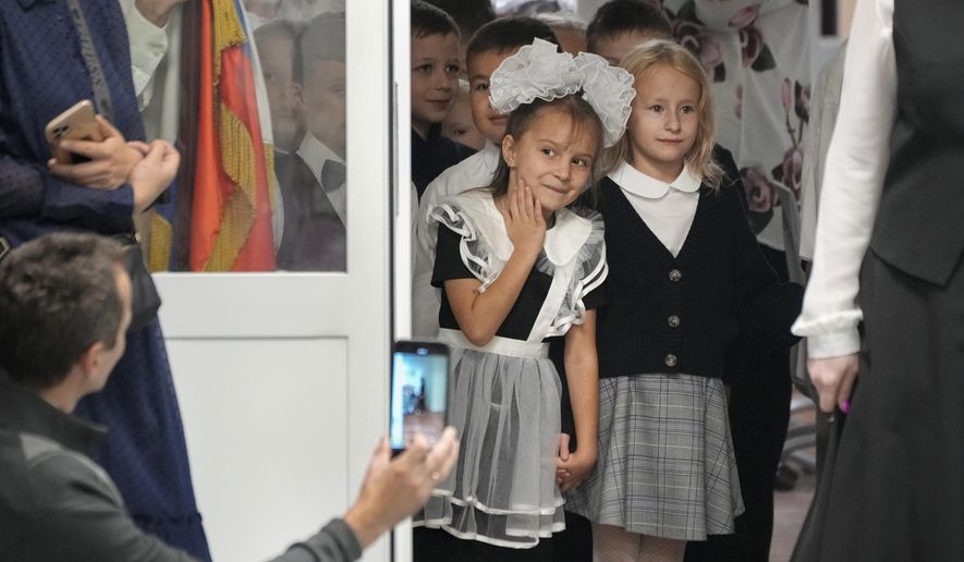 First graders enter a school to take part in a ceremony marking the start of classes as part of the traditional opening of the school year known as "Day of Knowledge" in St. Petersburg, Russia, Monday, Sept. 2, 2024. (AP Photo/Dmitri Lovetsky) ** FILE **