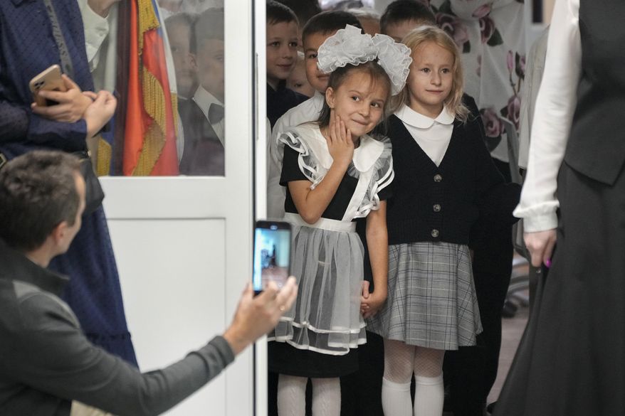 First graders enter a school to take part in a ceremony marking the start of classes as part of the traditional opening of the school year known as "Day of Knowledge" in St. Petersburg, Russia, Monday, Sept. 2, 2024. (AP Photo/Dmitri Lovetsky) ** FILE **