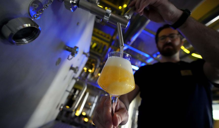 A brewmaster fills beer at a brewery in Freising, Germany, Friday, Sept. 20, 2024. (AP Photo/Matthias Schrader)