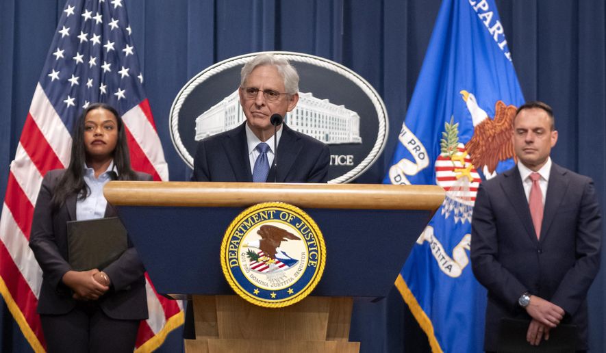Attorney General Merrick Garland, center, is flanked by Principal Deputy Assistant Attorney General Doha Mekki, left, and Principal Deputy Associate Attorney General Benjamin Mizer, right, as he speaks during a news conference at the Department of Justice, Tuesday, Sept. 24, 2024, in Washington. (AP Photo/Mark Schiefelbein)