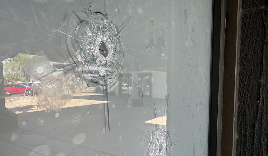 Bullet holes remain in the glass window at a Democratic Party campaign office in Tempe, Ariz., Wednesday, Sept. 25, 2024. (AP Photo/Gabriel Sandoval)