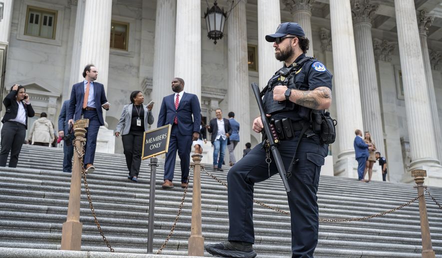 A U.S. Capitol Police officer stands watch as lawmakers leave the House of Representatives after voting on an interim spending bill to avoid a government shutdown next week, at the Capitol in Washington, Wednesday, Sept. 25, 2024. (AP Photo/J. Scott Applewhite)