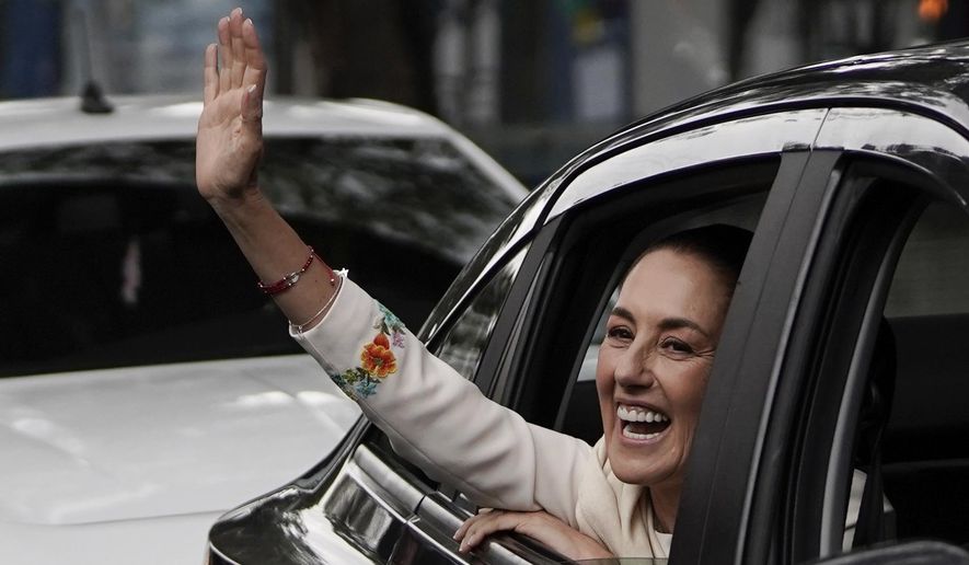 Claudia Sheinbaum waves from the vehicle taking her to Congress where she will be sworn in as president in Mexico City, Tuesday, Oct. 1, 2024. (AP Photo/Aurea Del Rosario)