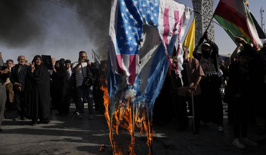 Demonstrators burn representations of the U.S. and Israeli flags in a rally commemorating slain Hezbollah leader Hassan Nasrallah, in Tehran, Iran, Wednesday, Oct. 2, 2024. (AP Photo/Vahid Salemi)