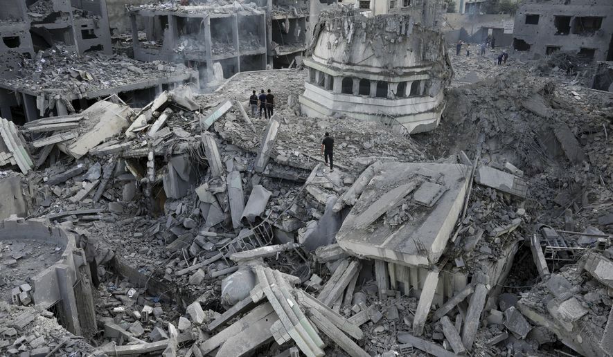 Palestinians inspect the rubble of the Yassin Mosque destroyed after it was hit by an Israeli airstrike at Shati refugee camp in Gaza City, early Monday, Oct. 9, 2023. Israel's military battled to drive Hamas fighters out of southern towns and seal its borders Monday as it pounded the Gaza Strip. (AP Photo/Adel Hana, File)