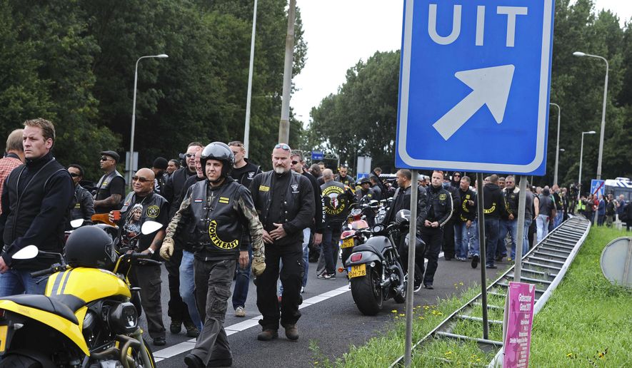 Members of the Satudarah (One Blood) motorcycle gang leave after Dutch riot police blocked a group of 150 riders on the A2 motorway at the entrance to Amsterdam, Netherlands, Sept. 4, 2011, to prevent from entering the capital where a gathering of Harley Davidson riders took place. The sign at right reads "exit". (AP Photo/Evert Elzinga, File)