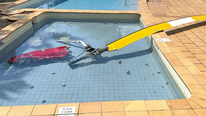 This image made from video and supplied by Australia's national transport safety investigator, shows helicopter debris in a hotel swimming pool after it crashed in August 2024. (Australia's national transport safety investigator via AP)