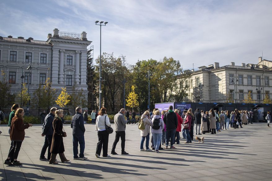 Voters queue at the polling station during the advance voting in the first round of a parliamentary election in Vilnius, Lithuania, Wednesday, Oct. 9, 2024. (AP Photo/Mindaugas Kulbis)