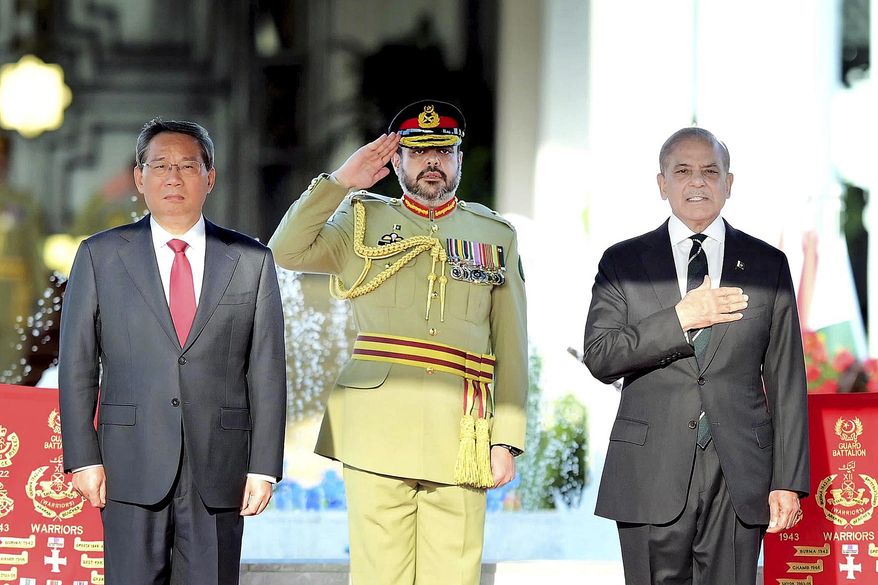 In this photo released by the Press Information Department, visiting China's Premier Li Qiang, left, and Pakistan's Prime Minister Shehbaz Sharif attend a attends a welcome ceremony, in Islamabad, Pakistan, Monday, Oct. 14, 2024. (Press Information Department via AP)