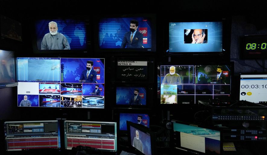 TV anchor Nesar Nabil is seen on studio monitors wearing a face mask to protest the Taliban's new order that female presenters cover their faces, as he reads the news on TOLOnews, in Kabul, Afghanistan, Sunday, May 22, 2022. (AP Photo/Ebrahim Noroozi, File)