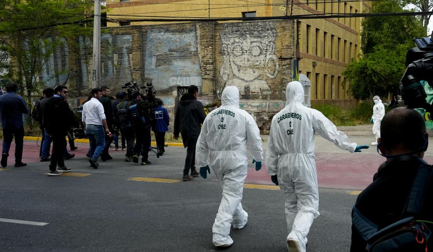 Authorities head inside the Barros Arana National Boarding School after a fire in Santiago Chile, Wednesday, Oct. 23, 2024. (AP Photo/Esteban Felix)