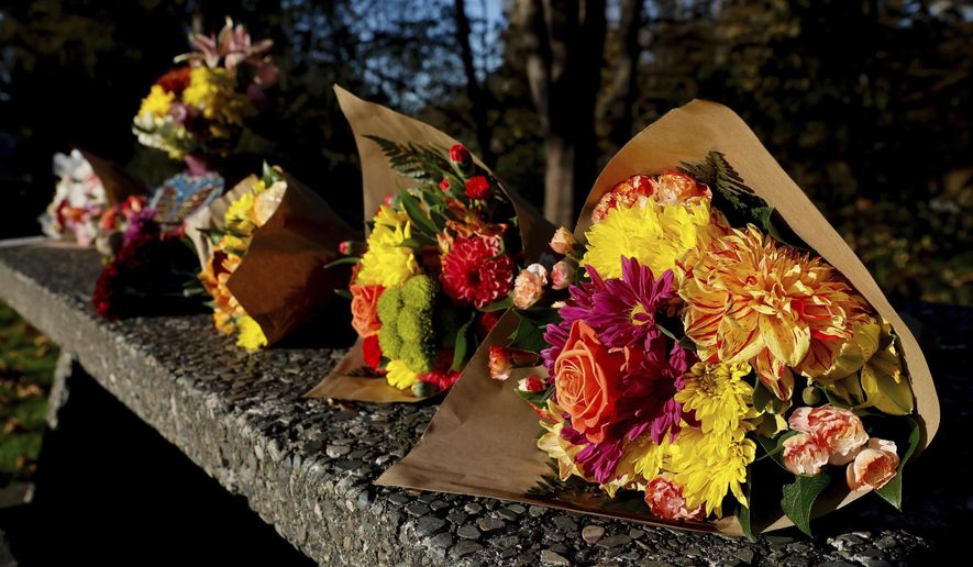Bouquets line a stone picnic table at a roadside park as a small memorial to the victims of a mass shooting the day before in Fall City, Wash., Tuesday, Oct. 22, 2024. (Jennifer Buchanan/The Seattle Times via AP, File)