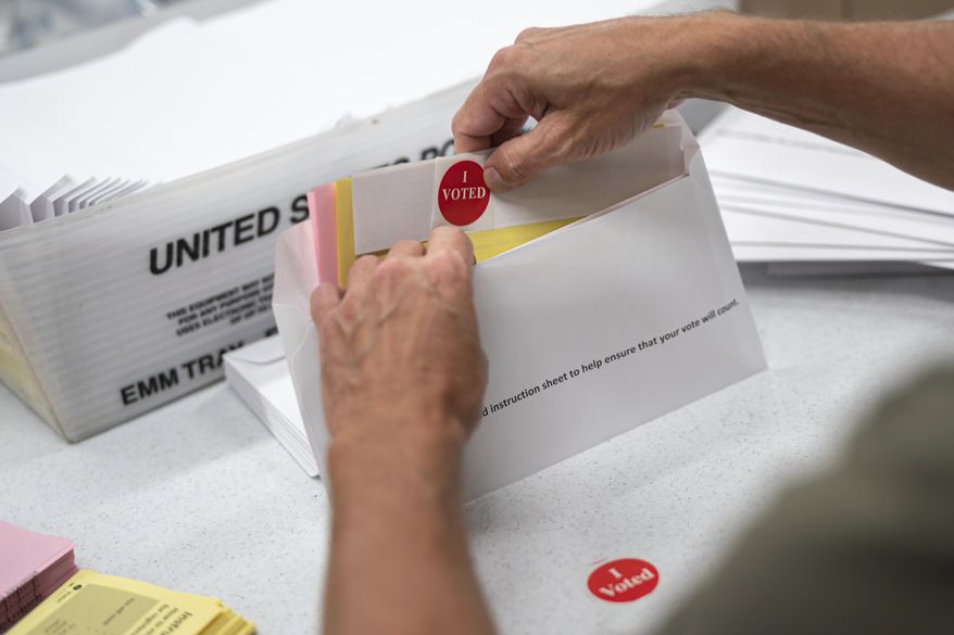 Mail in ballot envelopes including an I Voted sticker are prepared in Minneapolis, July 29, 2020. (Glen Stubbe/Star Tribune via AP, File)