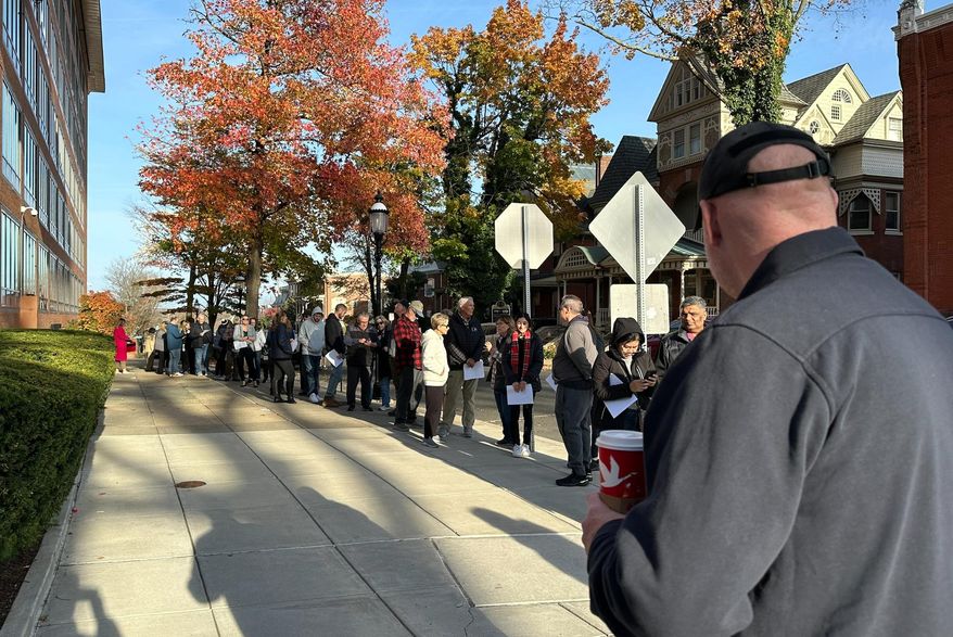 People wait in line outside the Bucks County government building to apply for an on-demand mail ballot on the last day to request one in Doylestown, Pa., Tuesday, Oct. 29, 2024. (AP Photo/Mike Catalini)