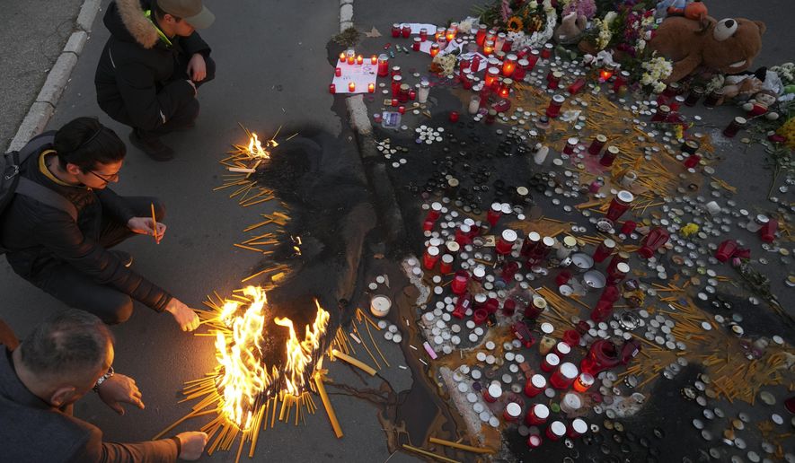People light candles for the victims of an outdoor roof collapse at a train station in Novi Sad, Serbia, Saturday, Nov. 2, 2024. (AP Photo/Darko Vojinovic)