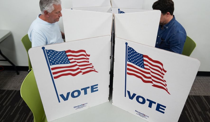People mark their ballots at the polling place at Tysons-Pimmit Regional Library in Falls Church, Va., Thursday, Oct. 31, 2024. (AP Photo/Stephanie Scarbrough)