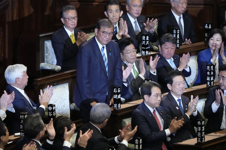 Lawmakers applaud as Japanese Prime Minister Shigeru Ishiba, standing, was elected for a new prime minister at a special parliamentary session of the lower house Monday, Nov. 11, 2024, in Tokyo. (AP Photo/Eugene Hoshiko)
