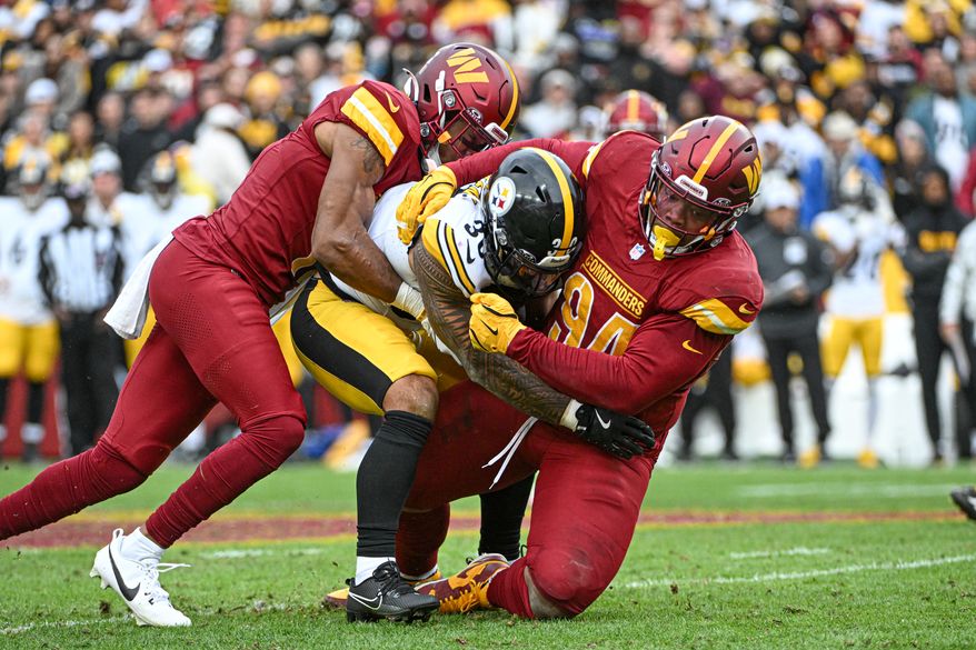 Pittsburgh Steelers running back Jaylen Warren (30) getting tackled by Washington Commanders nose tackle Daron Payne (94) and safety Jeremy Chinn (11) during the first half of an NFL game at Northwest Stadium in Landover, MD, November 10, 2024. (Photo for the Washington Times)