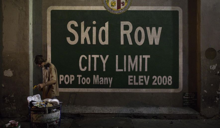 A homeless man takes food from a trash can in Los Angeles' Skid Row area, home to the nation's largest concentration of homeless people, Saturday, Oct. 28, 2017, in Los Angeles. (AP Photo/Jae C. Hong,File)