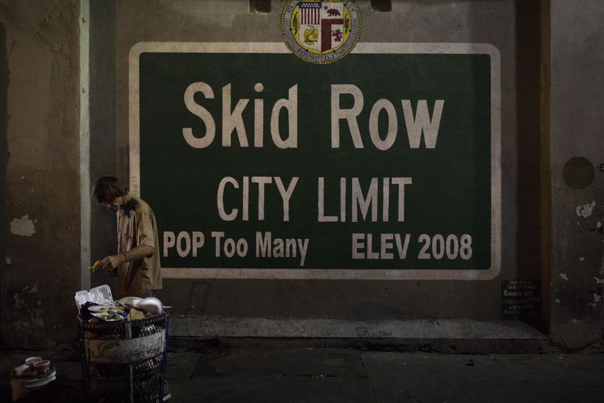 A homeless man takes food from a trash can in Los Angeles' Skid Row area, home to the nation's largest concentration of homeless people, Saturday, Oct. 28, 2017, in Los Angeles. (AP Photo/Jae C. Hong,File)