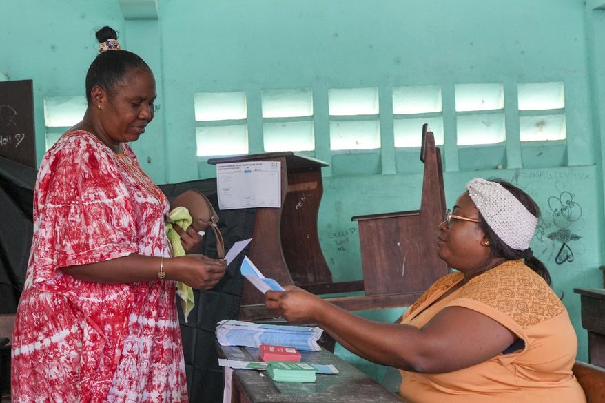 A woman votes in a referendum on whether to adopt a new constitution, in Libreville, Gabon, Saturday, Nov. 16, 2024. (AP Photo/Betines Makosso)