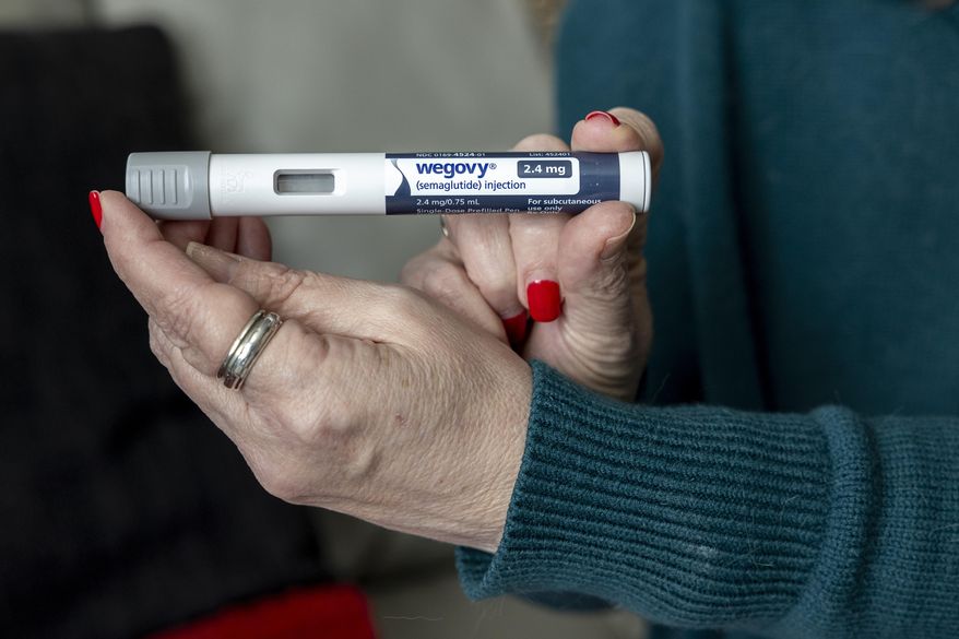 Donna Cooper holds up a dosage of Wegovy, a drug used for weight loss, at her home, March 1, 2024, in Front Royal, Va. (AP Photo/Amanda Andrade-Rhoades, File)