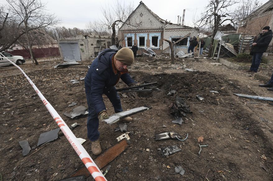 A police forensic expert inspects fragments of a Shahed drone, after a Russian strike on residential neighbourhood in Zaporizhzhia, Ukraine, Monday Nov. 25, 2024. (AP Photo/Kateryna Klochko)