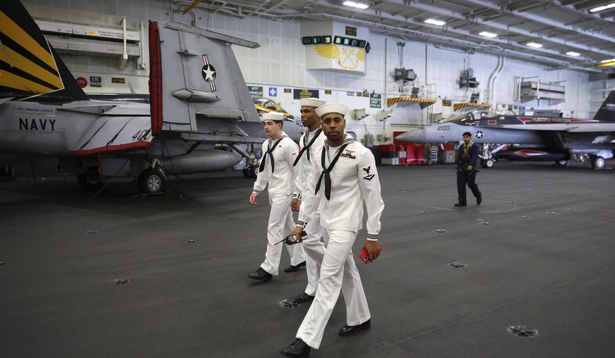U.S. Navy officers walk inside the USS Abraham Lincoln during a media tour in Port Klang, on the outskirts of Kuala Lumpur, Malaysia, Tuesday, Nov. 26, 2024.(Fazry Ismail/Pool Photo via AP)