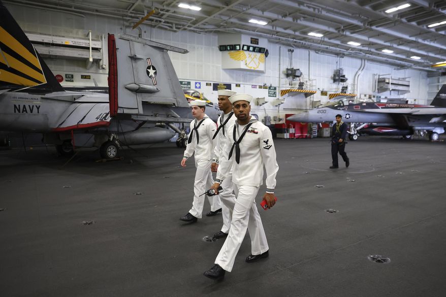 U.S. Navy officers walk inside the USS Abraham Lincoln during a media tour in Port Klang, on the outskirts of Kuala Lumpur, Malaysia, Tuesday, Nov. 26, 2024.(Fazry Ismail/Pool Photo via AP)